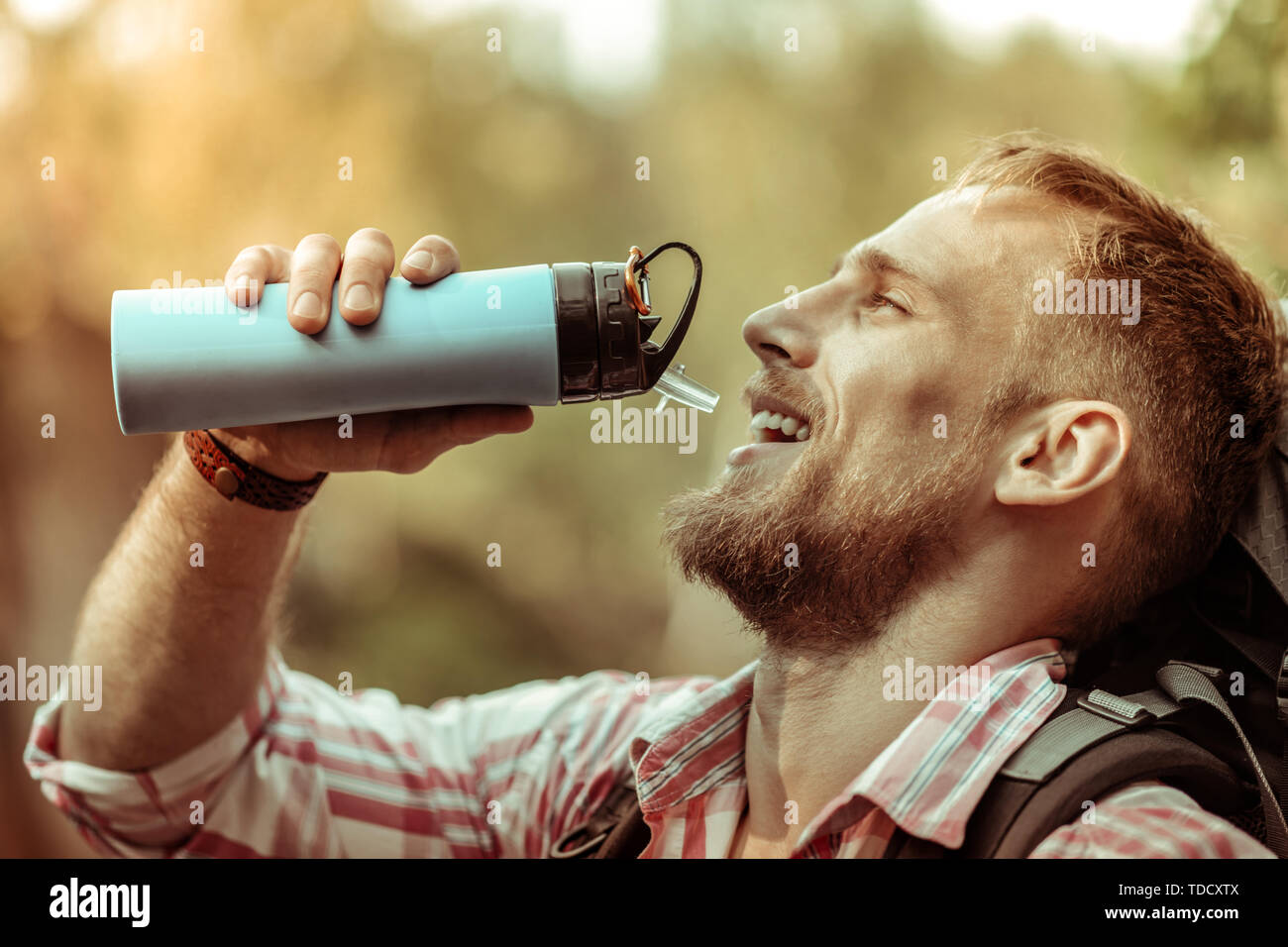Schönes erfreut, bärtigen Mann hält eine Thermosflasche Stockfoto
