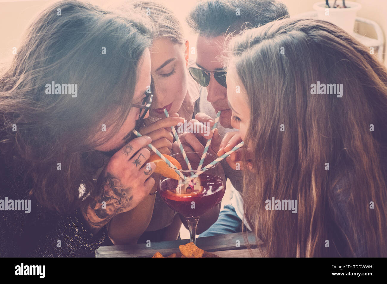 Team Freunde kaukasischen Jugendlichen Spaß in der Feier alle zusammen trinken aus dem gleichen cocktail Glas- und Freundschaft Konzept in der vin Stockfoto