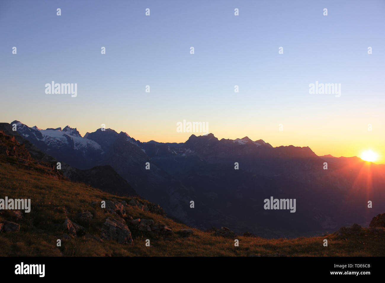 Sonnenuntergang in den Schweizer Bergen mit einem die Sonne hinter den Bergen Stockfoto
