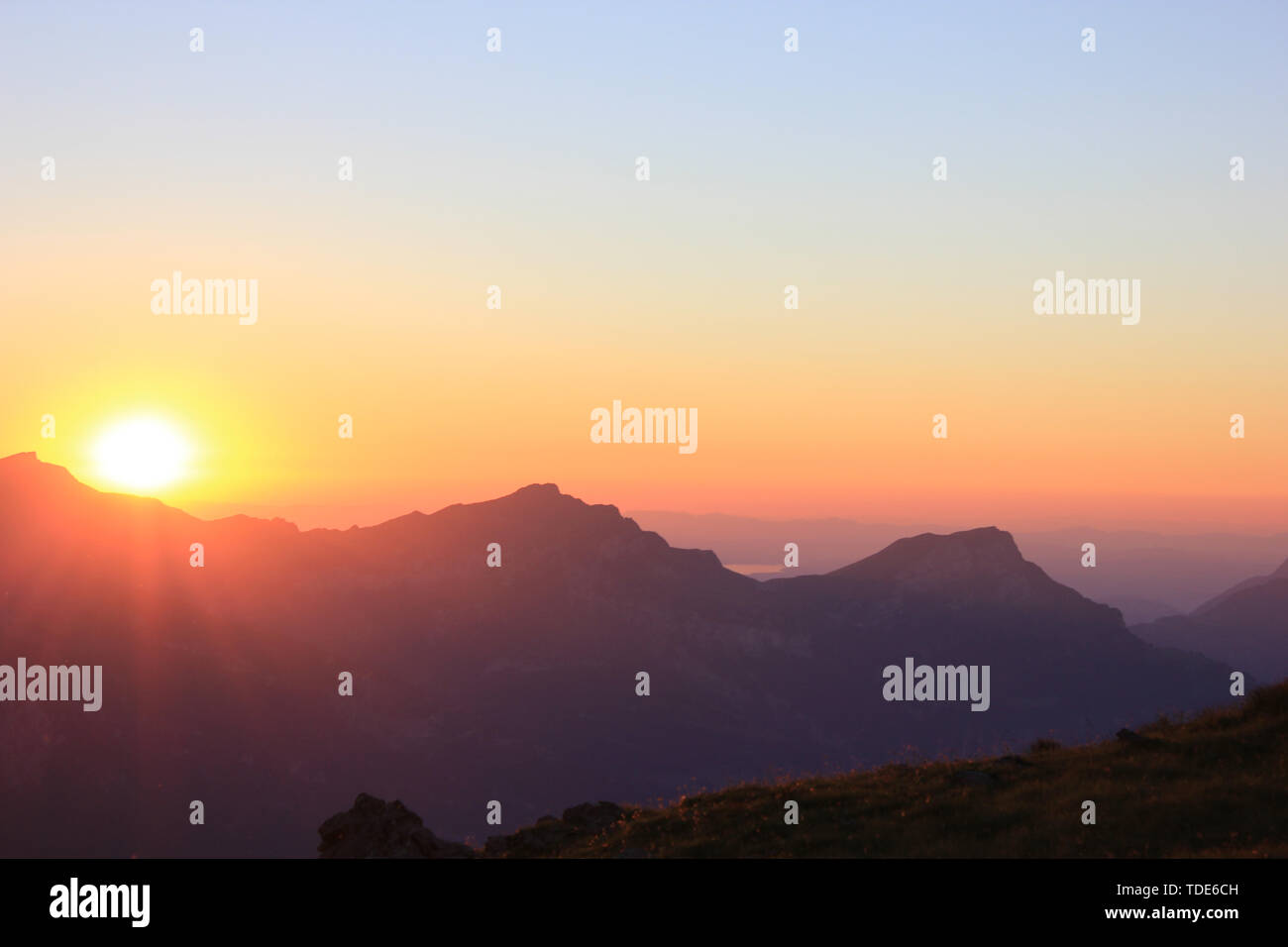 Sonnenuntergang in den Schweizer Bergen mit einem die Sonne hinter den Bergen Stockfoto