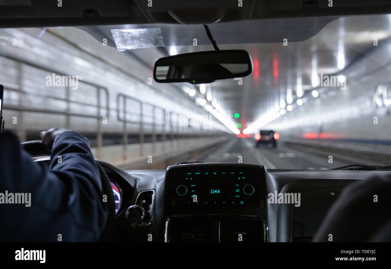 Lincoln Tunnel, New York. Männliche Taxi Fahrer mit dem Lenkrad. Nahaufnahme auf dem Armaturenbrett Stockfoto