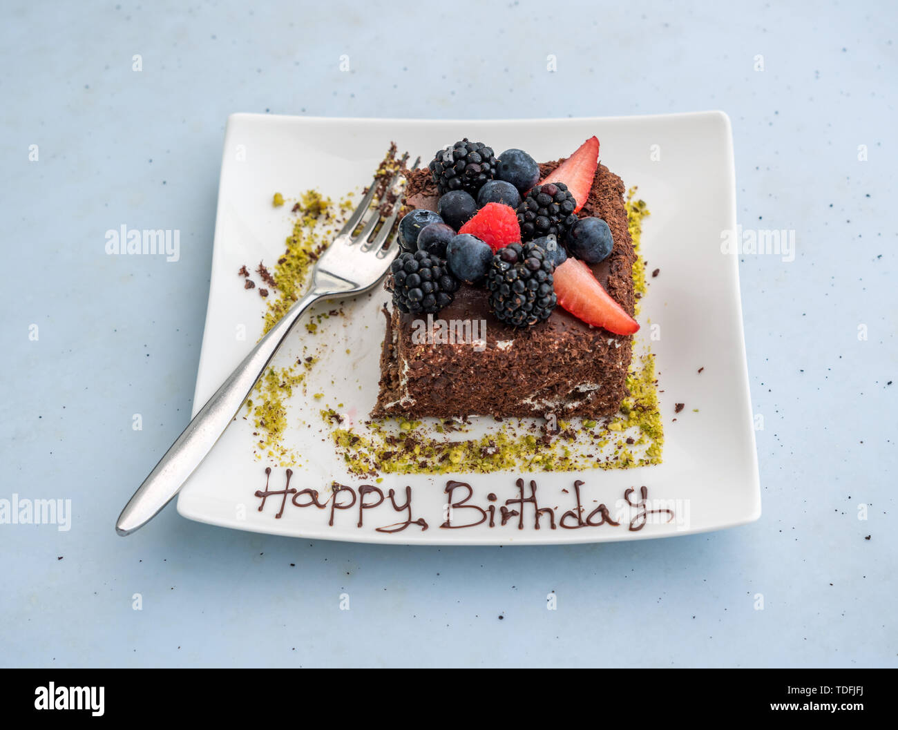 Happy Birthday in Sahnehäubchen auf Schokolade Kuchen geschrieben Stockfoto