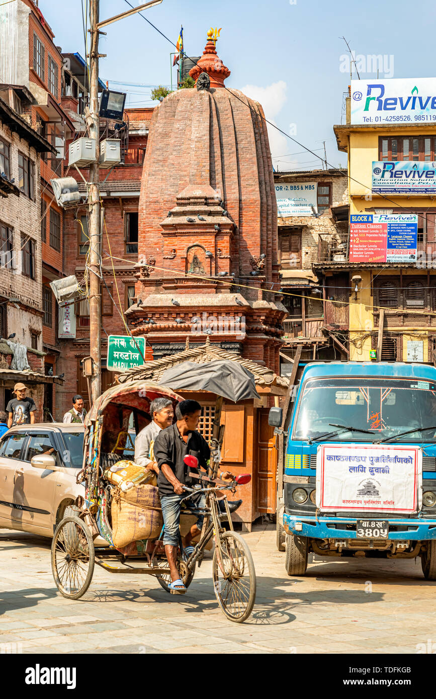 Kathmandu, Nepal - Oct 11, 2018: Mann, Radfahren auf einer Rikscha und Datenverkehr auf der schmalen Straße in der Nähe des Durbar Square in Kathmandu, Nepal. Stockfoto