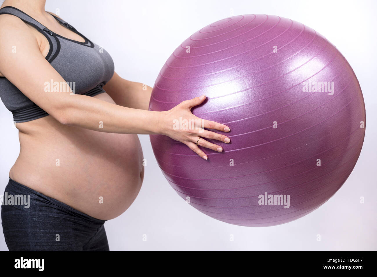 Junge schwangere Frau mit Fitness Ball und Training Stockfoto