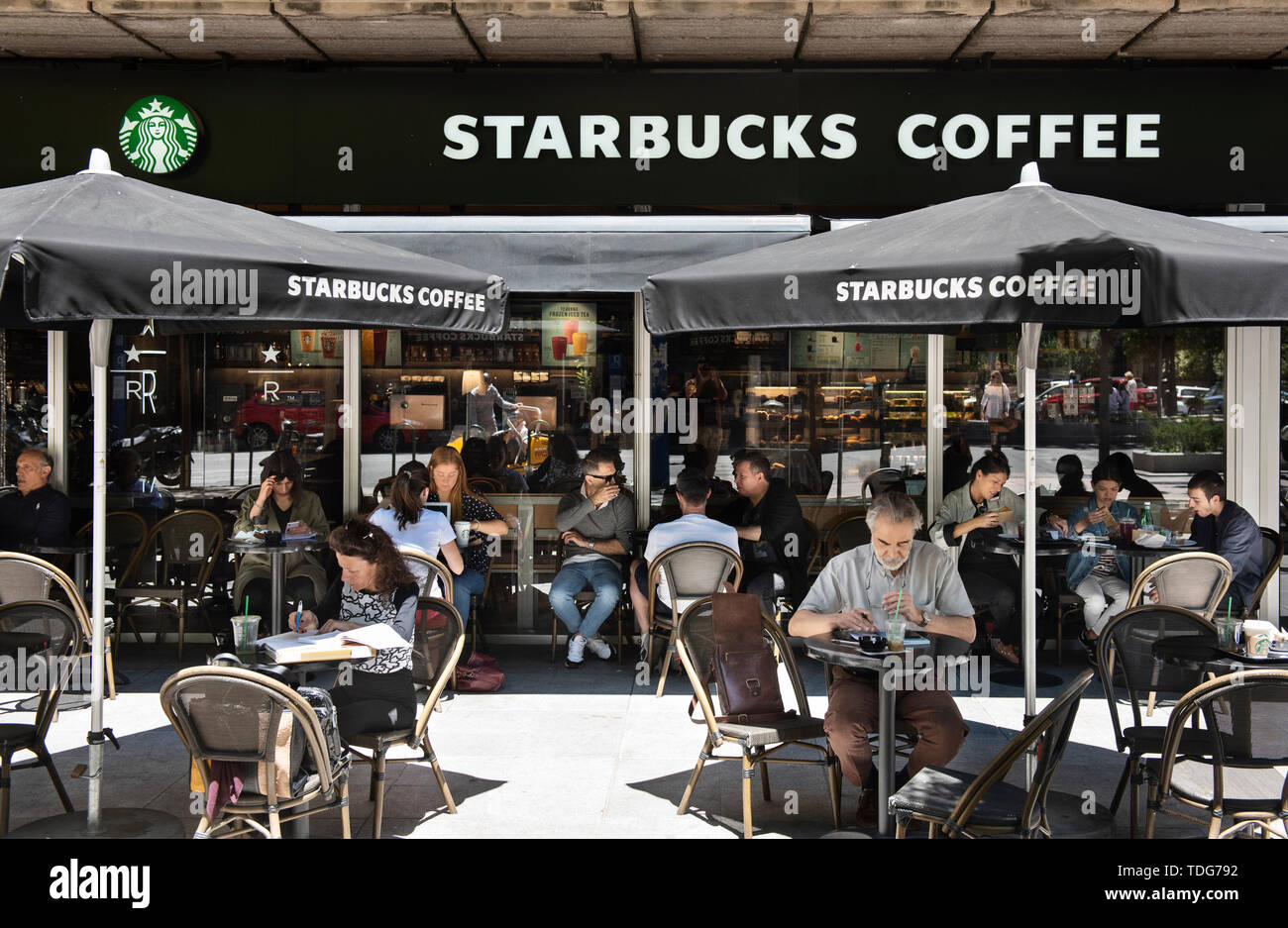 Kunden Kaffee trinken an der amerikanischen multinationalen Kette Starbucks Kaffee Restaurant in Spanien. Stockfoto