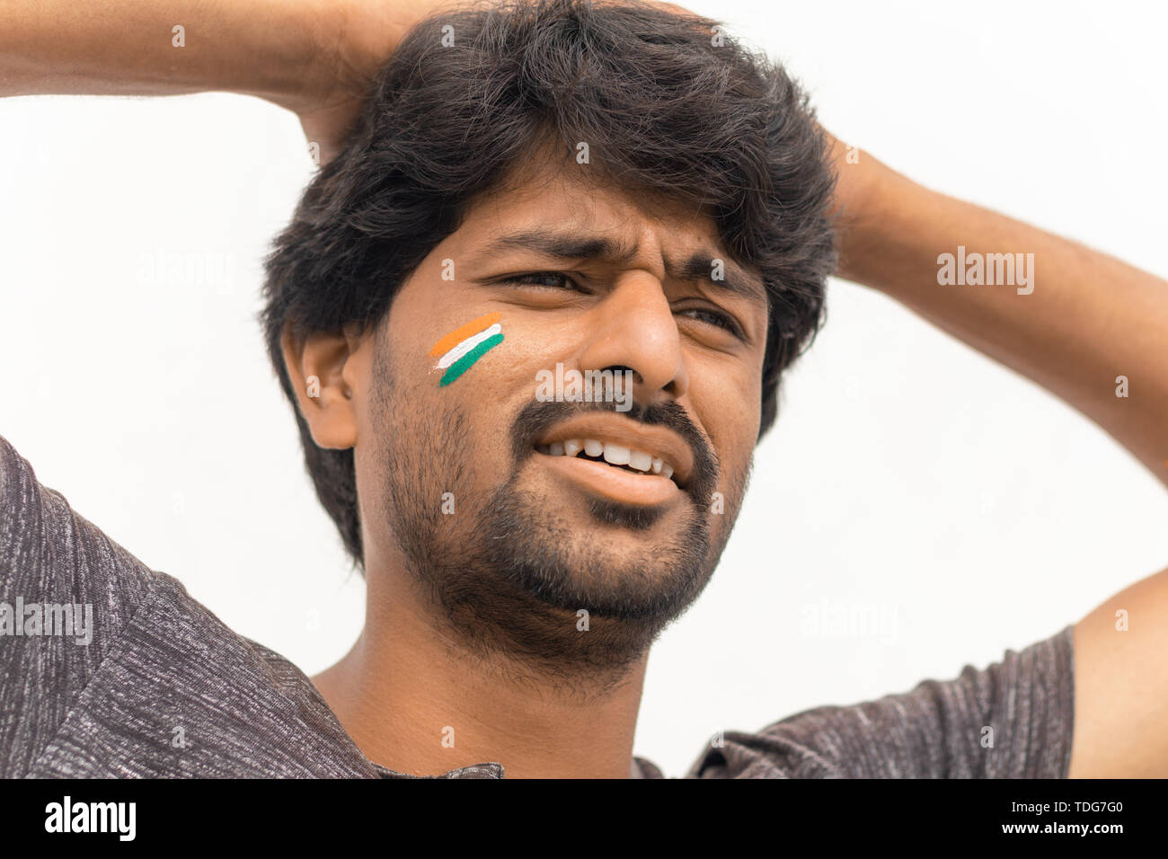Closeup Shot, traurigen Ausdruck der männlichen Indische Cricket Sport Ventilator mit gemalten indische Flagge auf dem Gesicht, isolierten Hintergrund Stockfoto