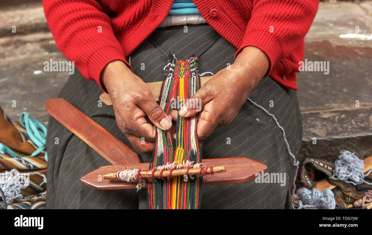 Peruanische Frau spinnt mit bunten Fäden auf einer Straße in Cusco, Peru Stockfoto