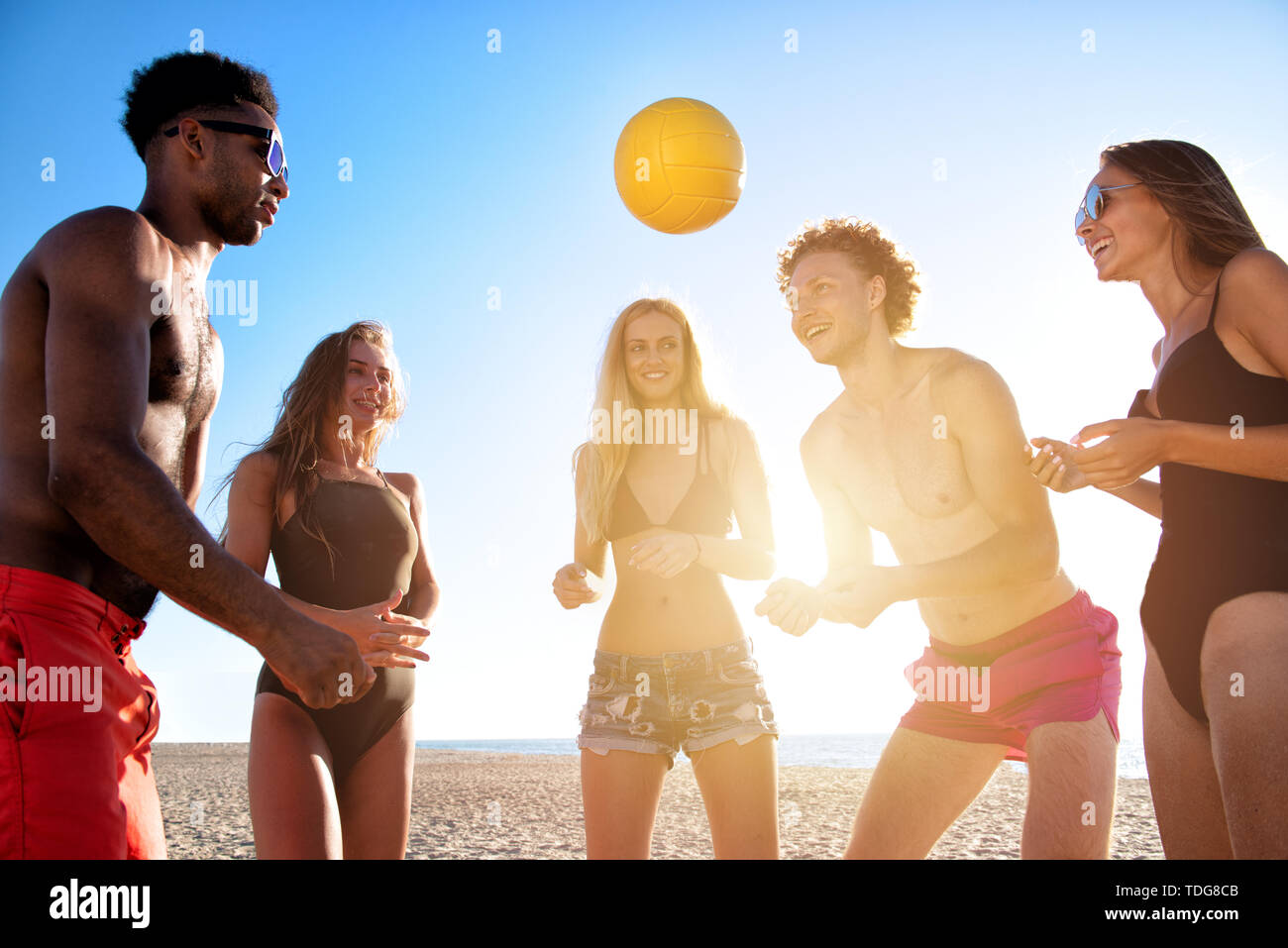 Gruppe von Freunden zu Beach-Volleyball am Strand spielen Stockfoto