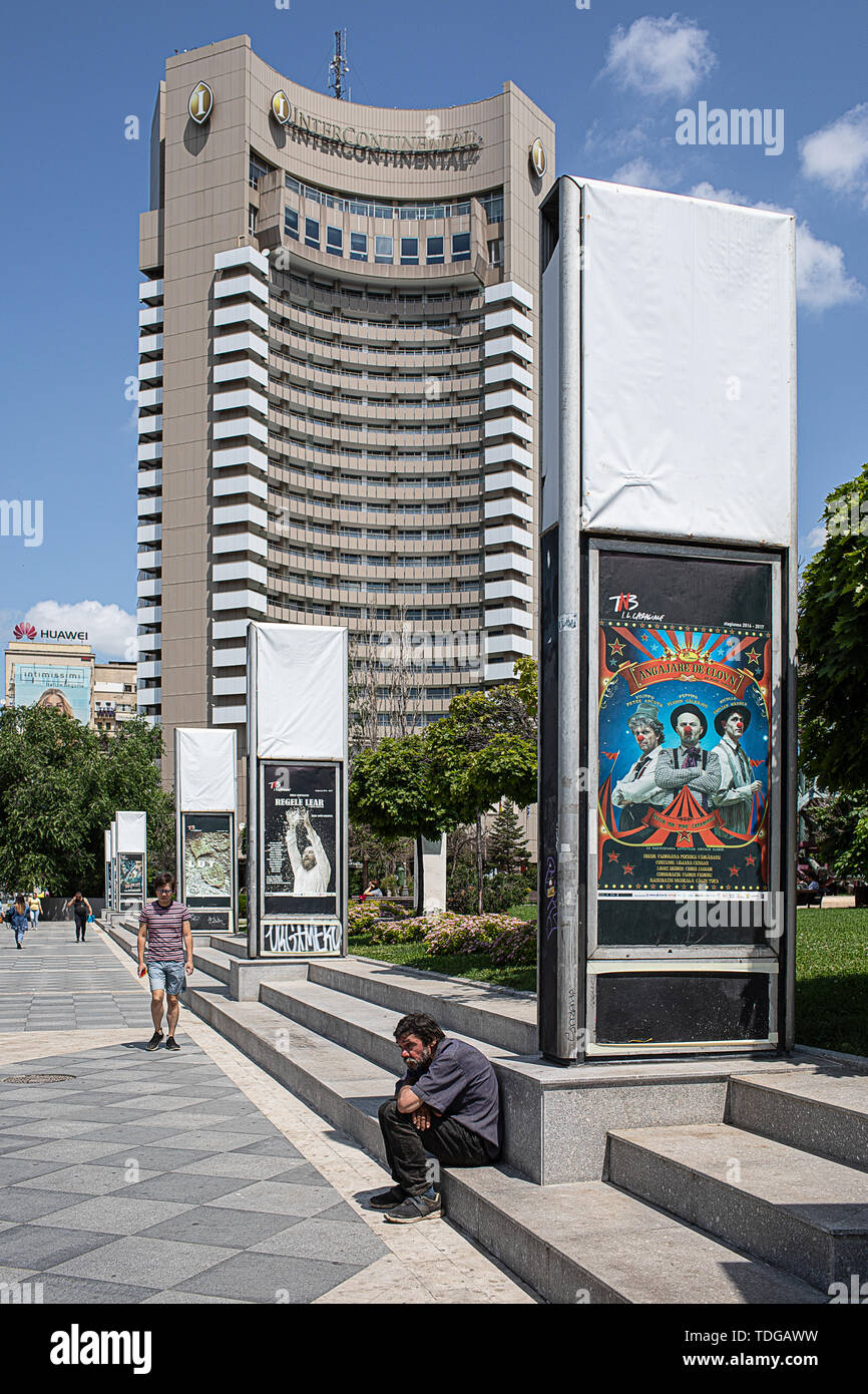 Bukarest, Rumänien - 30. Mai 2019: Antagonismus zwischen Armut und Reichtum der Innenstadt von Bukarest - arme Mann sitzt auf der Seite der Straße und Luxus in Stockfoto