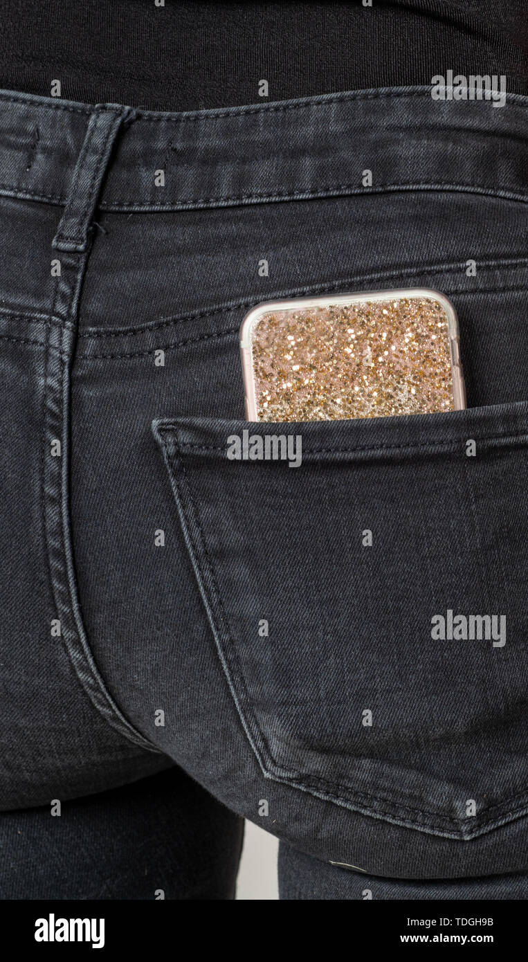 Mit Gold Diamond Hülse in der Tasche auf der Rückseite mit einer schwarzen Jeans auf ein Mädchen, das Smartphone Stockfoto