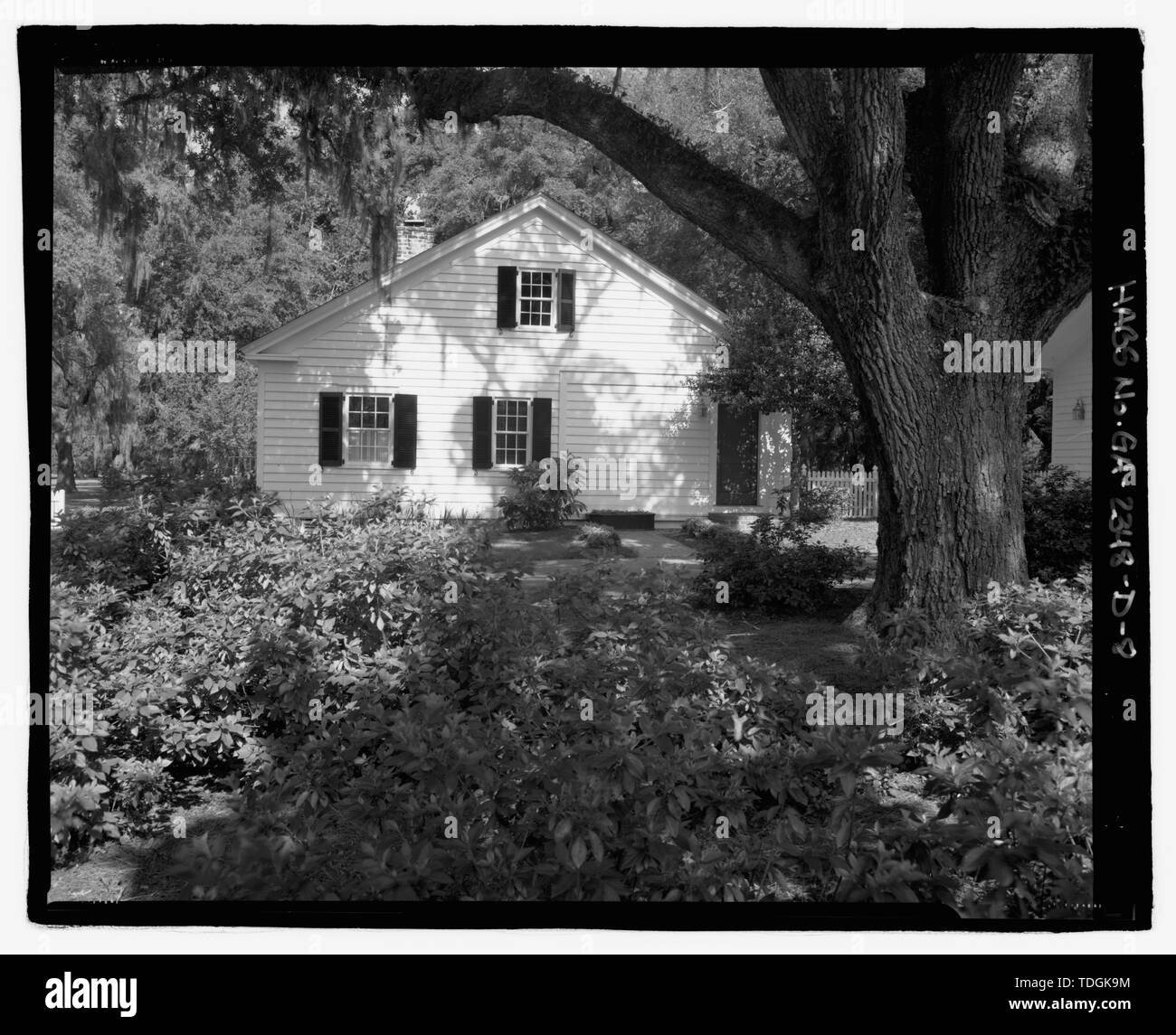 Nordwestseite der Hausmeister Haus mit großen Eichen und Büsche in den Vordergrund - Richmond Hill Plantation, Hausmeister's House, östlich von Richmond Hill auf Ford Hals Road, Richmond Hill, Bryan County, GA Stockfoto