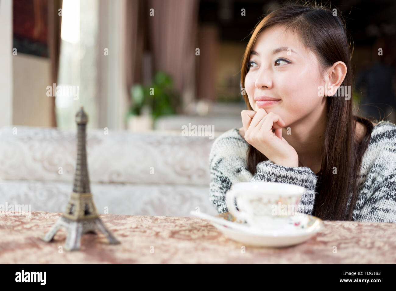 Junge hübsche chinesische Frau in modernen Cafe sitzen Stockfoto