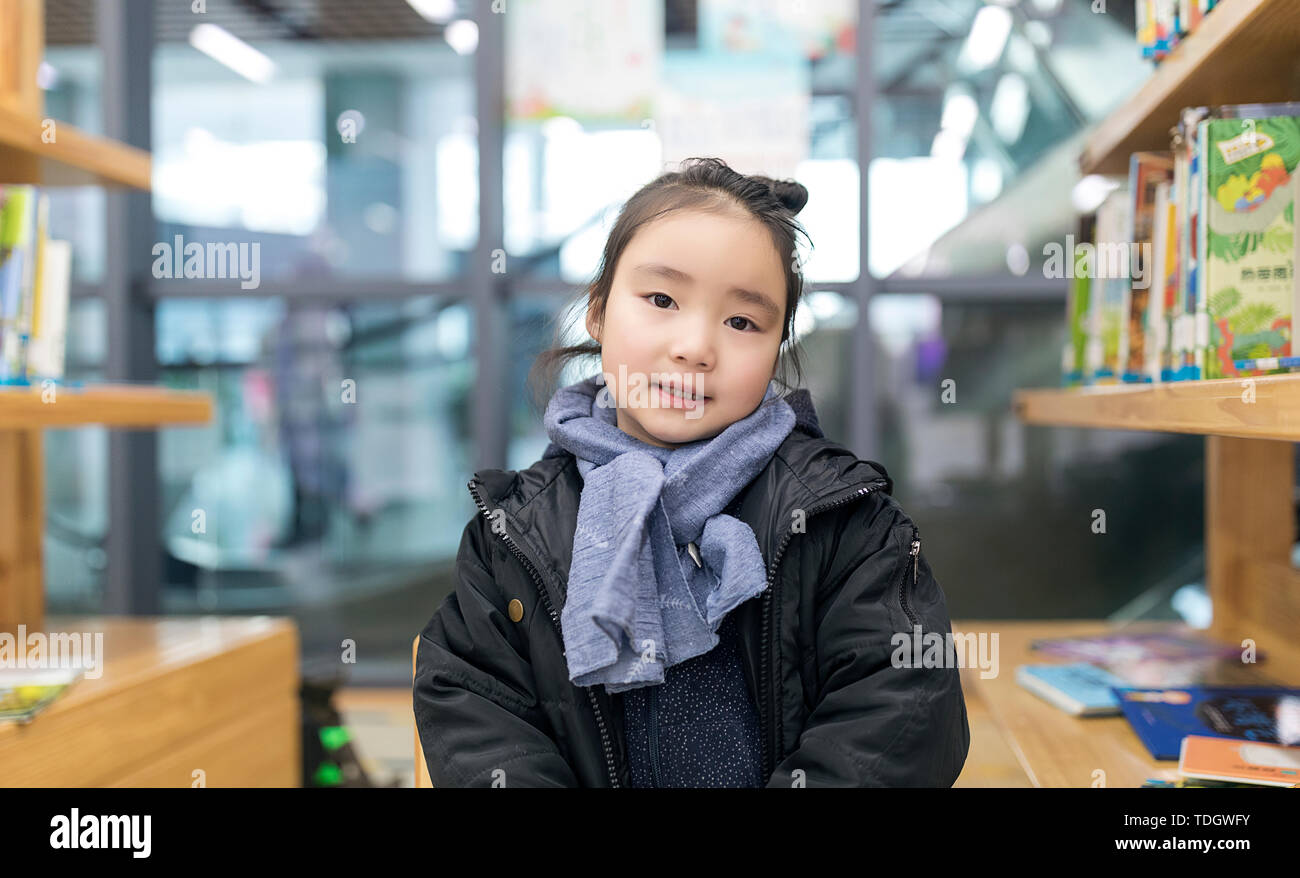 Wenig asiatisches Mädchen das Lesen in der Bibliothek Stockfoto