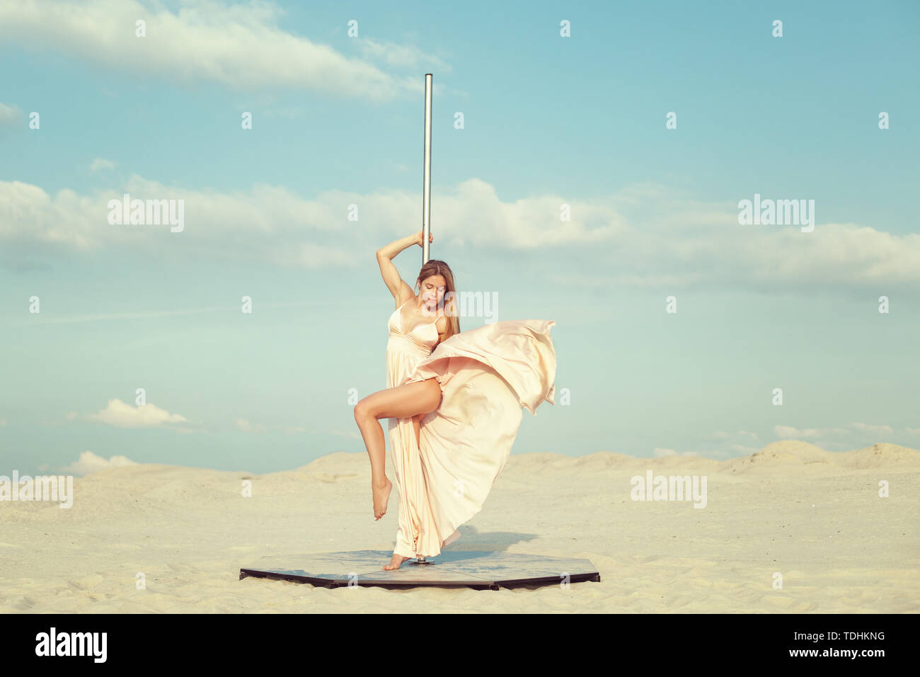 Schöne junge Frau in einem Kleid steht in der Nähe der Pylon in der Wüste. Stockfoto