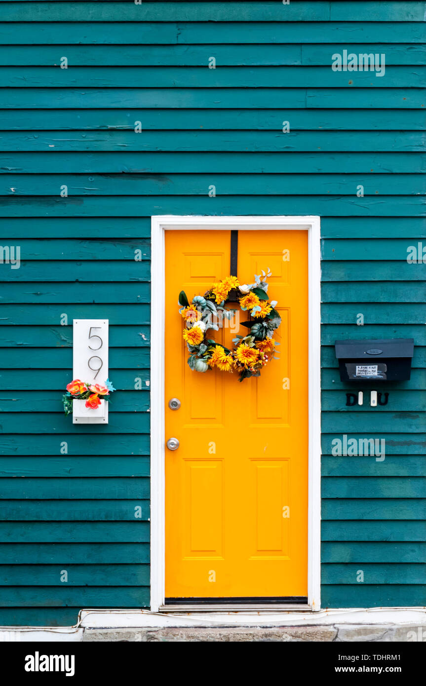Bunte vordere Tür, mit einem Lorbeerkranz, auf einem Haus in St. John's, Neufundland. Stockfoto