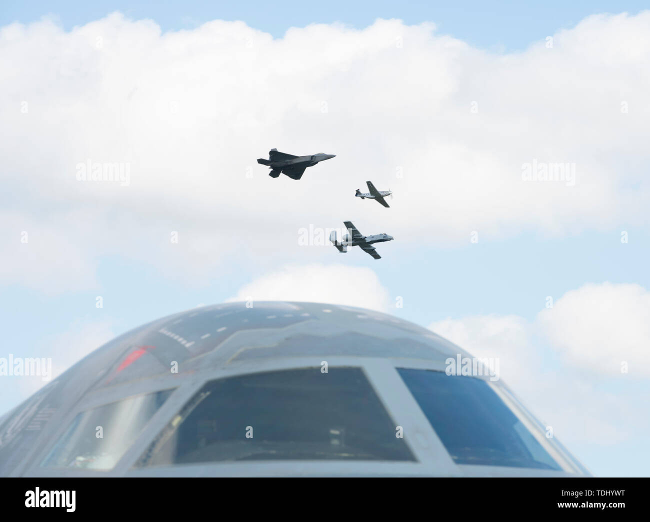 Eine F-22 Raptor, P-51 Mustang und ein A-10 Thunderbolt II fliegen in Formation über eine B-2 Stealth Bomber am 15. Juni 2019, an Whiteman Air Force Base, Missouri. Die Flugzeuge flogen zusammen als Teil der F-22 Raptor Demonstration Team Erbe performace während der 2019 Flügel über Whiteman für Luft- und Raumfahrt zeigen. (U.S. Air Force Foto: Staff Sgt. Kayla Weiß) Stockfoto