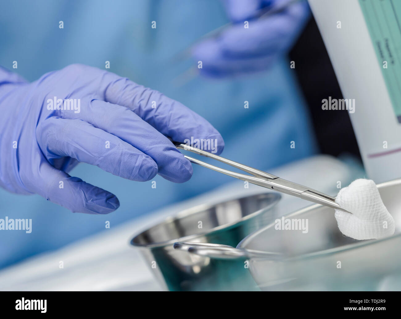 Chirurg im Operationssaal arbeiten, die Hände mit Handschuhen holding Schere mit torunda, konzeptionelle Bild, horizontale Zusammensetzung Stockfoto