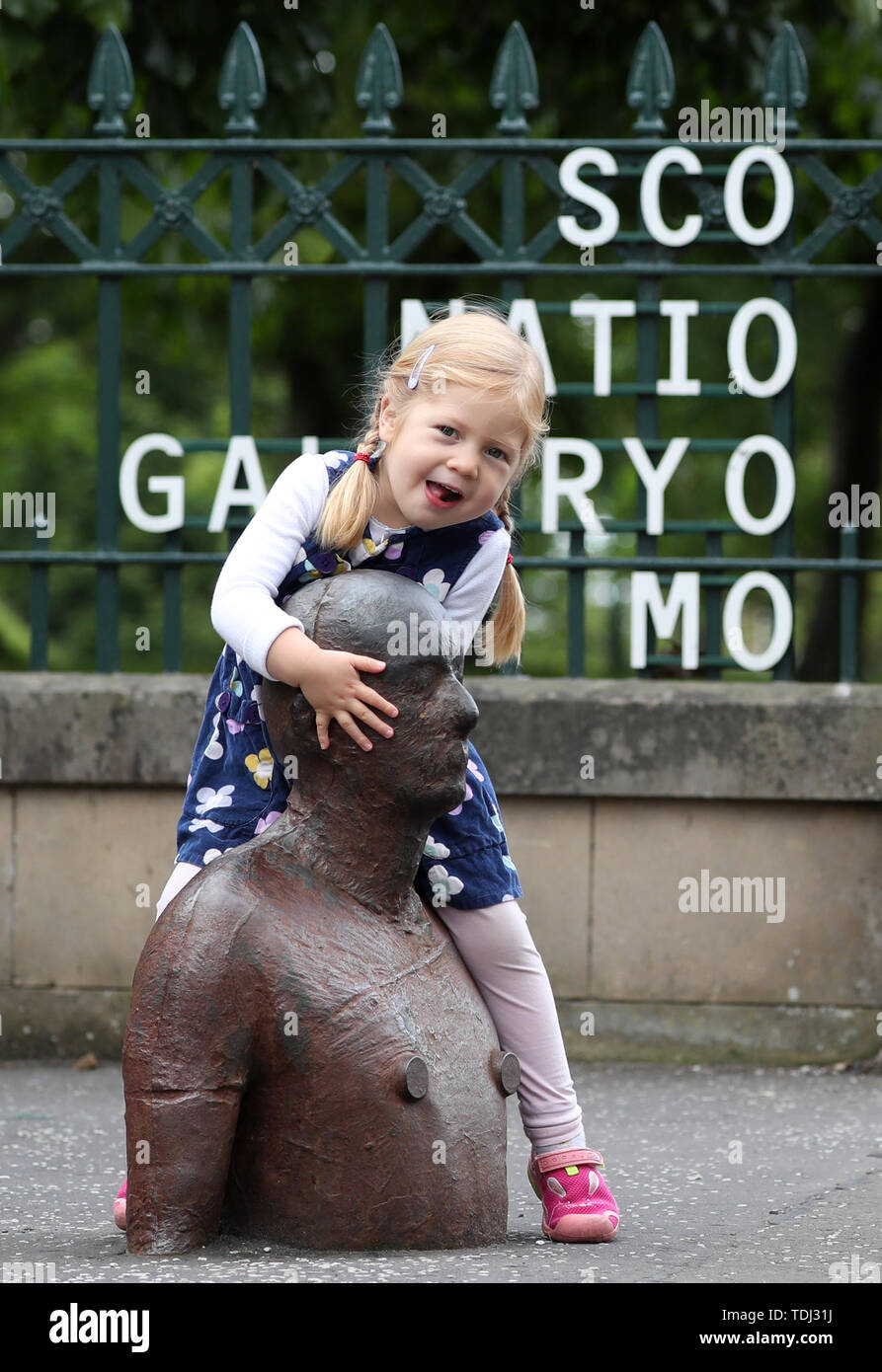 Phoebo Chisholm, 3, einen genaueren Blick auf "Goma" eine der sechs lebensgroße Bügeleisen zahlen nach Künstler Antony Gormley, die Teil der Installation "6 Mal" kennzeichnet eine wässrige Route entlang der Wasser des Leith Edinburgh von der Scottish National Gallery of Modern Art, das Meer in Leith Docks. Stockfoto
