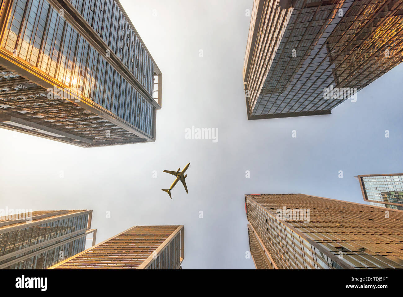 Flugzeuge fliegen über Wolkenkratzer im Finanzdistrikt Stockfoto