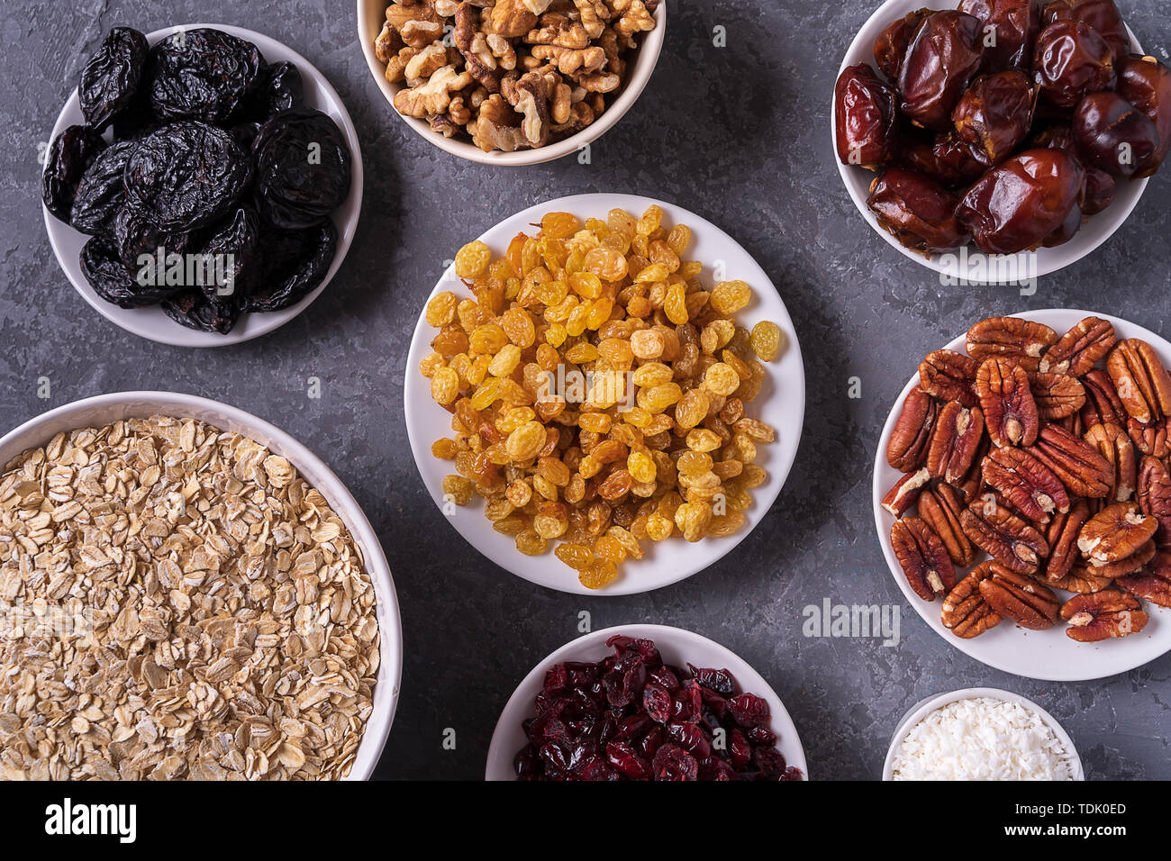 Zutaten für die Zubereitung von gesunder Bio Energie Kugeln - Termine, getrockneten Aprikosen, Haferflocken, Rosinen, getrocknete Cranberries, Pecan Nüsse, Kokos Späne auf g Stockfoto