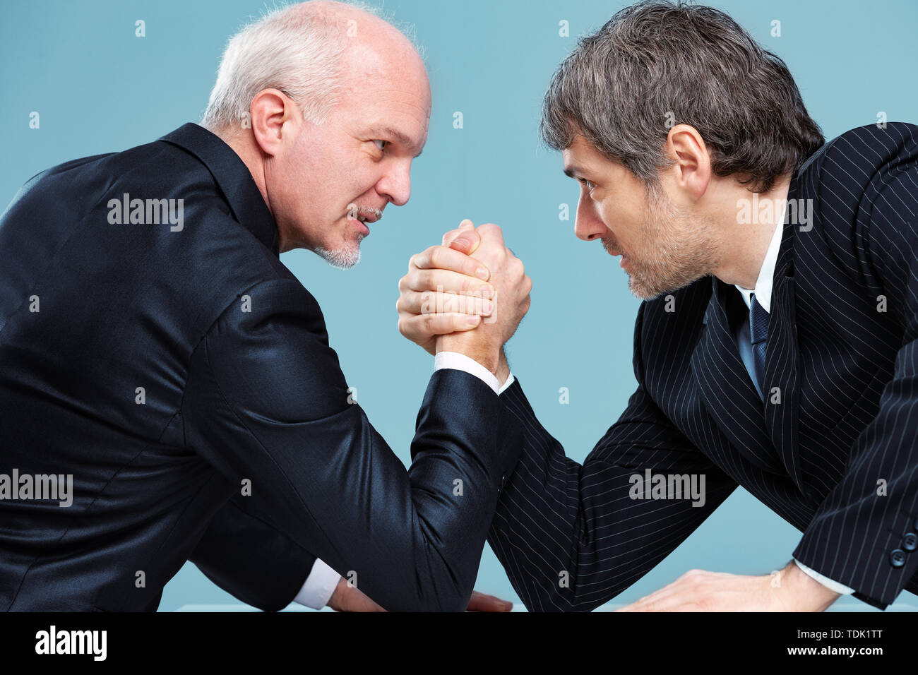Zwei Geschäftsleute Herausforderung jedes andere für eine Führungsposition, die versuchen, durch Armdrücken zu dominieren und starrte in die Augen Stockfoto