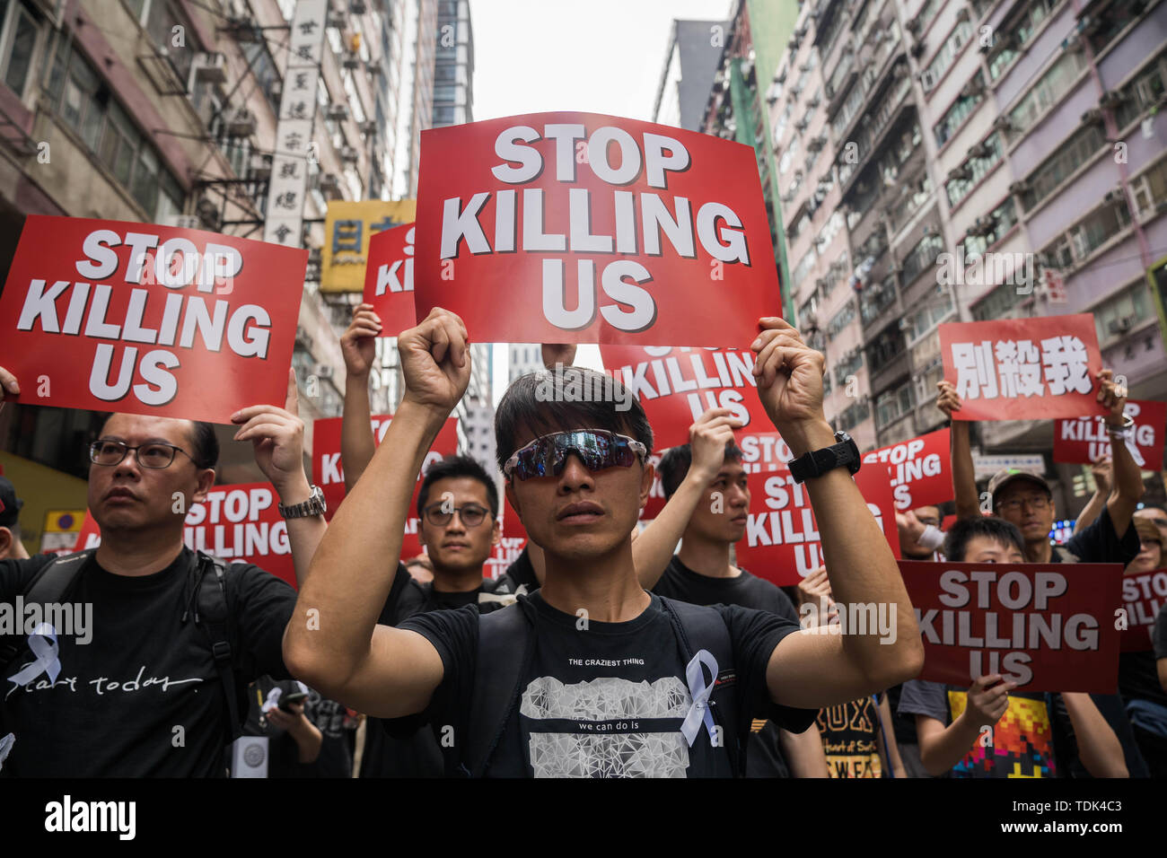 Die Demonstranten mit Plakaten, die liest'S top töten uns" während der Demonstration. Trotz versuchen, den Chief Executive Carrie Lam der Spannungen durch die Vereinbarung den umstrittenen Entwurf auszusetzen, in der Nähe von 2 Millionen Menschen in den Sonntag Rallye teilgenommen zu erleichtern, so die Veranstalter. Die Demonstranten forderten den Rücktritt der umstrittenen Auslieferung Rechnung, die Freigabe und nicht-strafrechtliche Verfolgung der Menschen durch die Ursache, Untersuchung, ob exzessive Gewaltanwendung durch die Polizei am 12. Juni verwendet wurden verhaftet, und der Rücktritt von Carrie Lam. Stockfoto