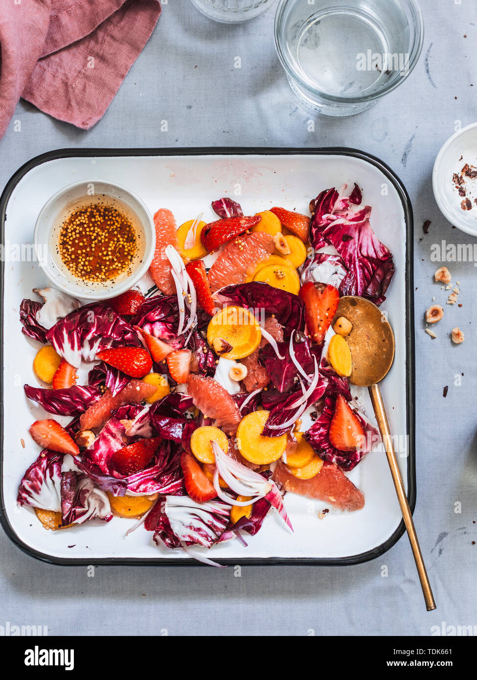 Radicchio Salat mit Regenbogen Karotten, Beeren, Früchten und Haselnüsse in Weiß Tablett serviert. Stockfoto