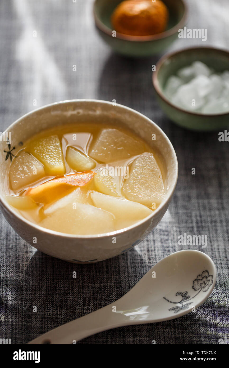 Eine warme Schüssel gekochtes Obst Suppe auf einem grau-blauen Tischdecke sah besonders ruhig in der Sonne auf der Rückseite. Stockfoto