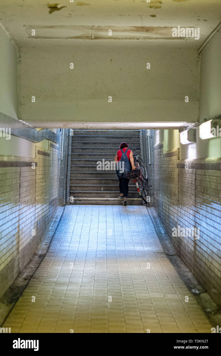 13. Juni 2019, Sachsen-Anhalt, Stendal: eine Frau drückt ihr Fahrrad auf der Seite einer Unterführung Treppe. In den kommenden Monaten wird die Deutsche Bahn die Station Barrierefrei auszubauen. Die Plattformen werden angehoben und die Unterführungen erneuert und mit Aufzügen ausgestattet. Foto: Klaus-Dietmar Gabbert/dpa-Zentralbild/ZB Stockfoto