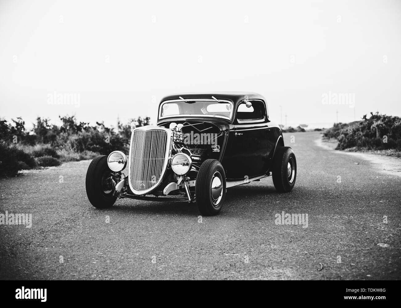 Schwarz-Weiß-Foto von einem alten Oldtimer geparkt Mitten auf der Autobahn Stockfoto