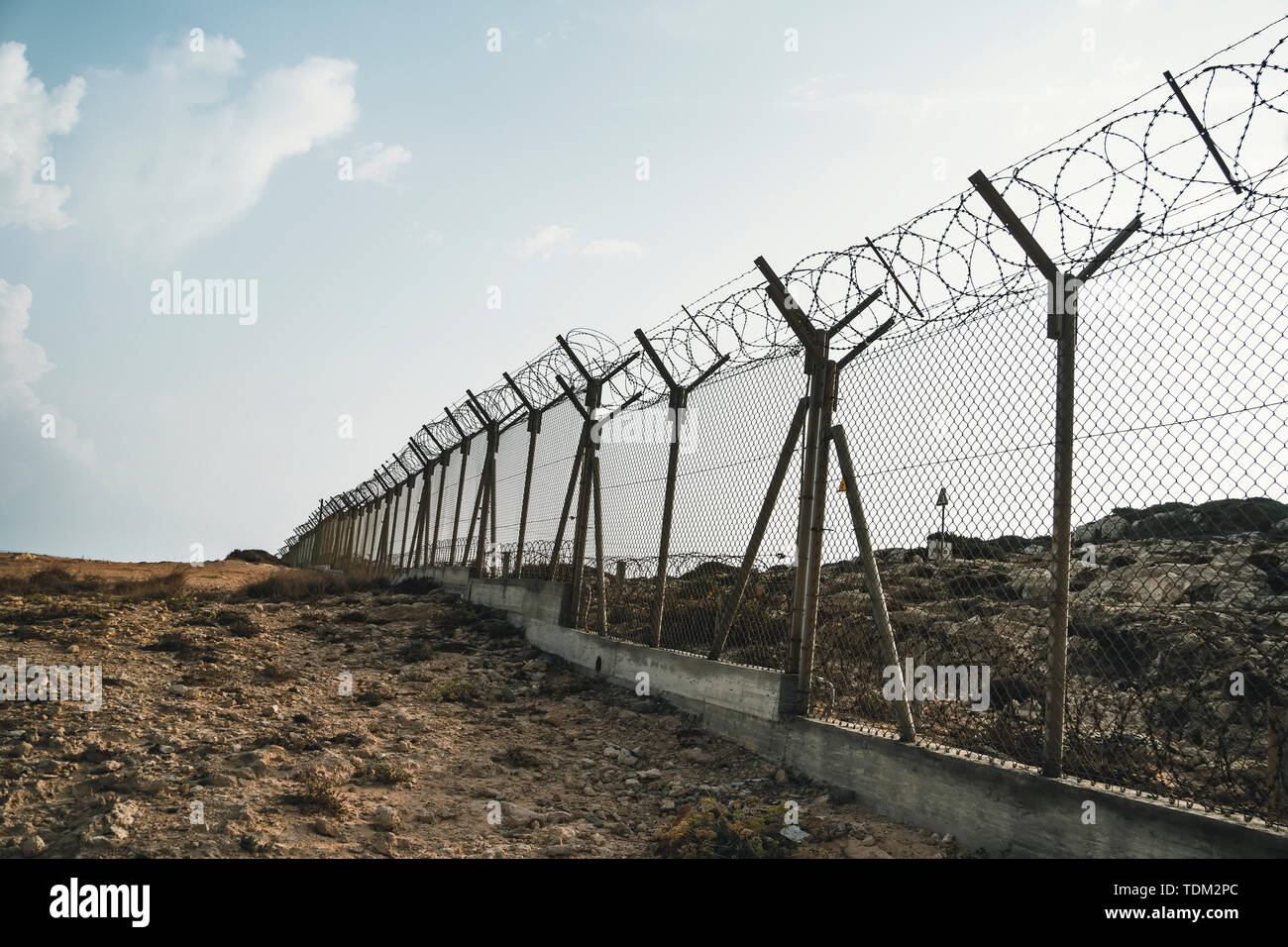 Stacheldraht aus Stahl gegen immigations. Mauer mit Stacheldraht an der Grenze von 2 Ländern. Private oder militärisches Sperrgebiet vor dem Hintergrund Stockfoto