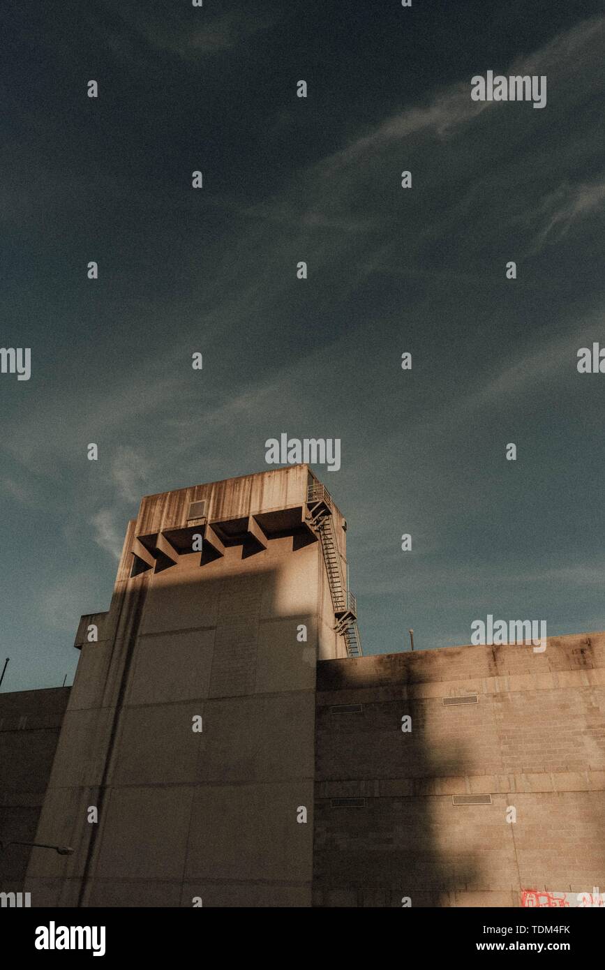 Hohe Wand mit einem Turm mit einem dunklen Himmel in Der Hintergrund Stockfoto