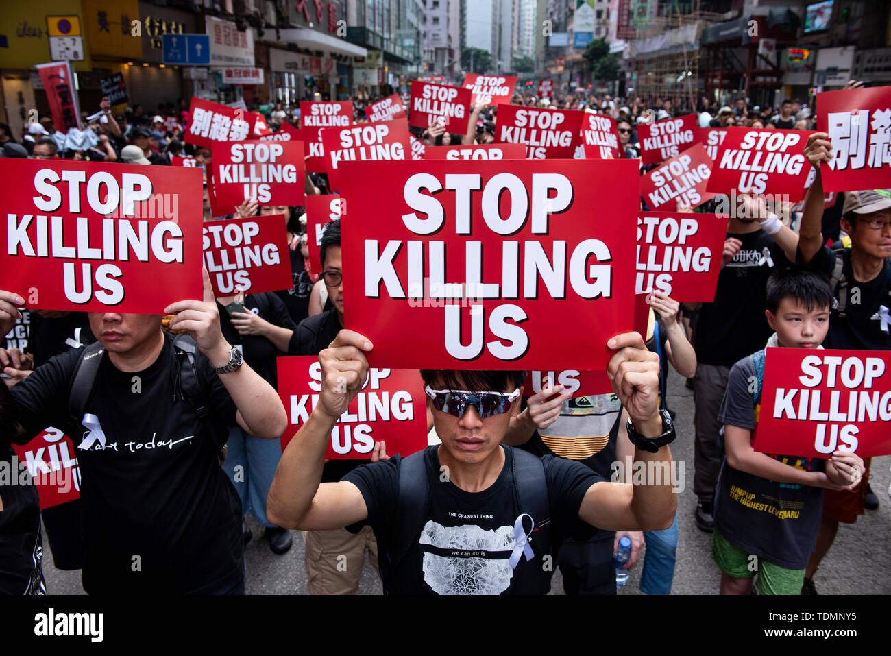 Die Demonstranten mit Plakaten, die liest'S top töten uns" während der Demonstration. Trotz versuchen, den Chief Executive Carrie Lam der Spannungen durch die Vereinbarung den umstrittenen Entwurf auszusetzen, in der Nähe von 2 Millionen Menschen in den Sonntag Rallye teilgenommen zu erleichtern, so die Veranstalter. Die Demonstranten forderten den Rücktritt der umstrittenen Auslieferung Rechnung, die Freigabe und nicht-strafrechtliche Verfolgung der Menschen durch die Ursache, Untersuchung, ob exzessive Gewaltanwendung durch die Polizei am 12. Juni verwendet wurden verhaftet, und der Rücktritt von Carrie Lam. Stockfoto