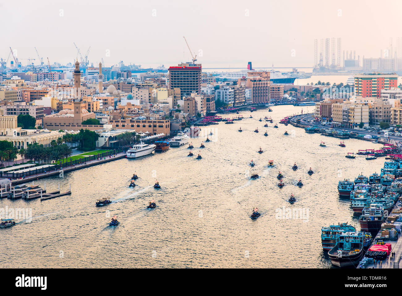 Dubai, Vereinigte Arabische Emirate - Juni 4, 2019: Boote schwimmend auf dem Dubai Creek in Deira mit der Ansicht des Alten Dubai in Vereinigte Arabische Emirate Stockfoto