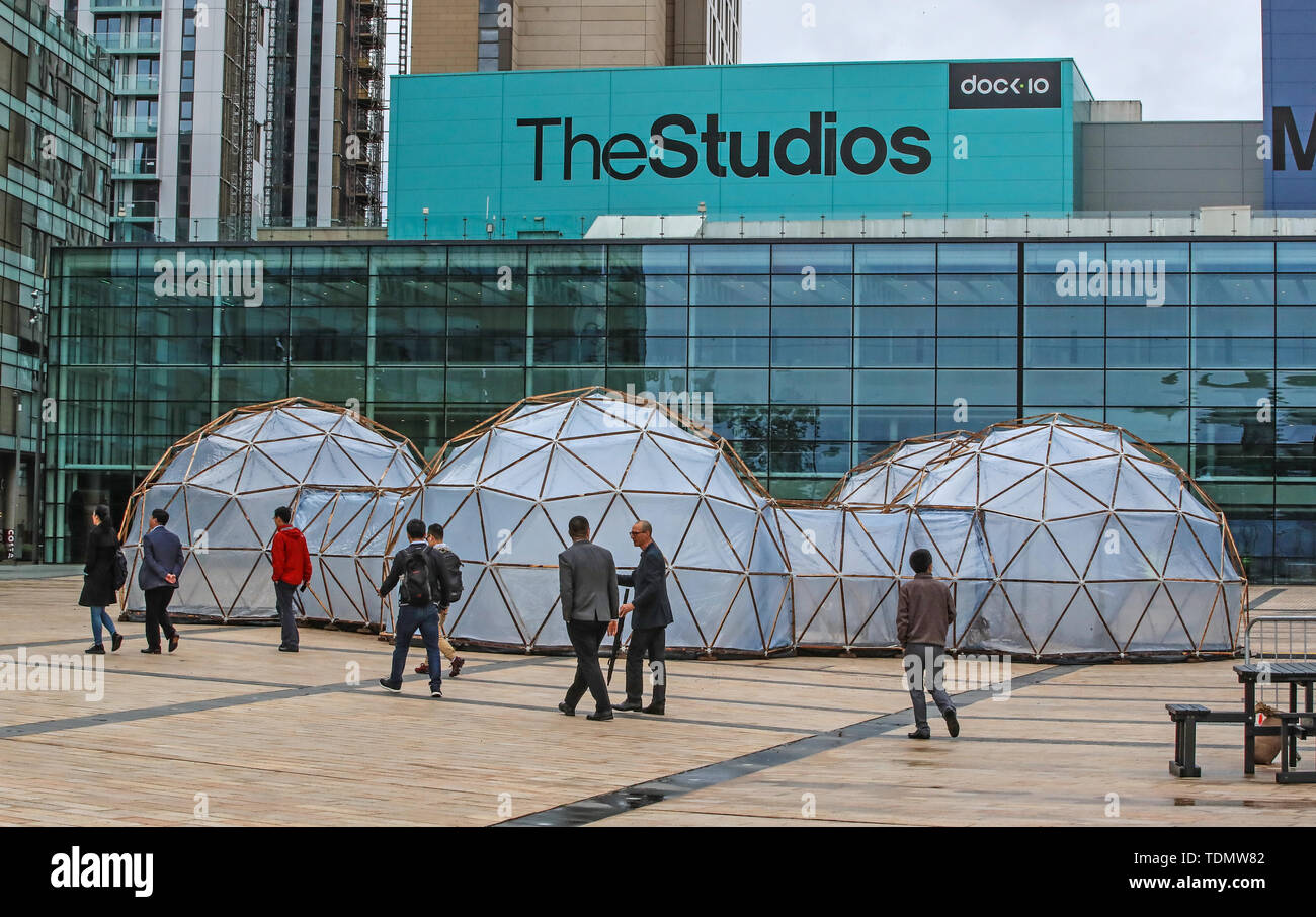 Menschen gehen vorbei Verschmutzung Pods eingebaut von Cleanairgm.com an MediaCityUK in Manchester. Die Leute können die Luftqualität in Städten auf der ganzen Welt von sauberer Luft von Tautra in Norwegen und den Smog und die Verschmutzung von London, New Delhi, Peking und Sao Paolo, in der Freien airpods repliziert. Stockfoto