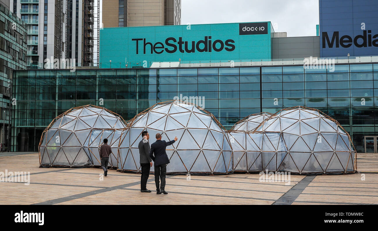 Leute schauen auf Verschmutzung Pods eingebaut von Cleanairgm.com an MediaCityUK in Manchester. Die Leute können die Luftqualität in Städten auf der ganzen Welt von sauberer Luft von Tautra in Norwegen und den Smog und die Verschmutzung von London, New Delhi, Peking und Sao Paolo, in der Freien airpods repliziert. Stockfoto