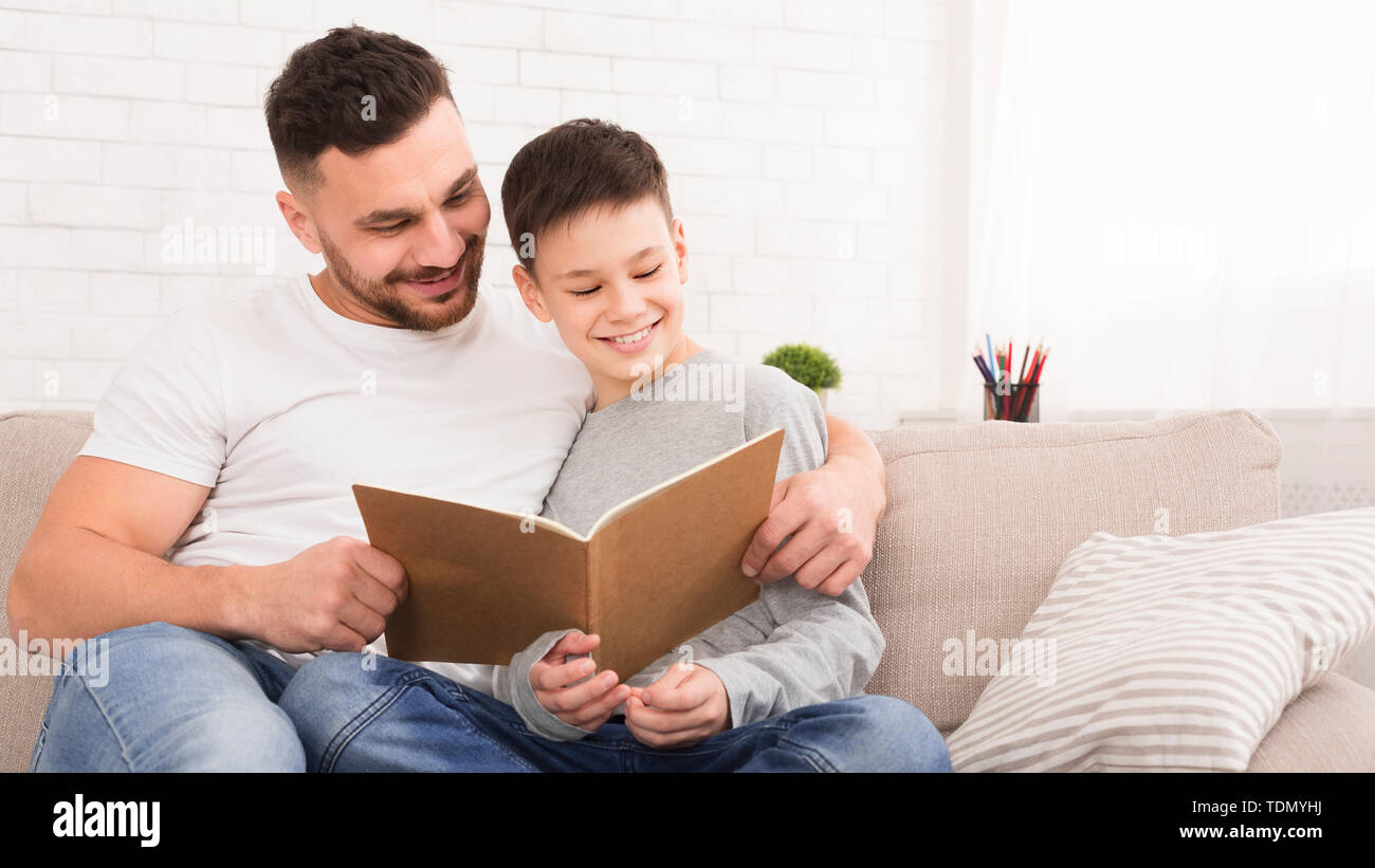 Vater und Sohn lesen Buch, Zeit gemeinsam zu Hause Stockfoto