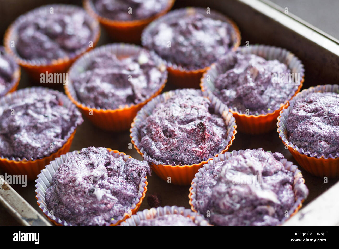 Bereiten Sie glutenfreie Heidelbeere Muffin. Raw lila Teig in Backformen Stockfoto