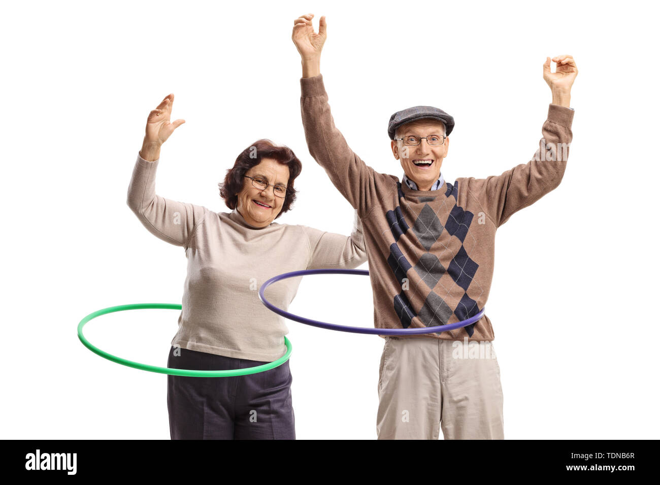 Männliche und weibliche Senioren mit Hula-Hoop-Reifen tanzen auf weißem Hintergrund Stockfoto