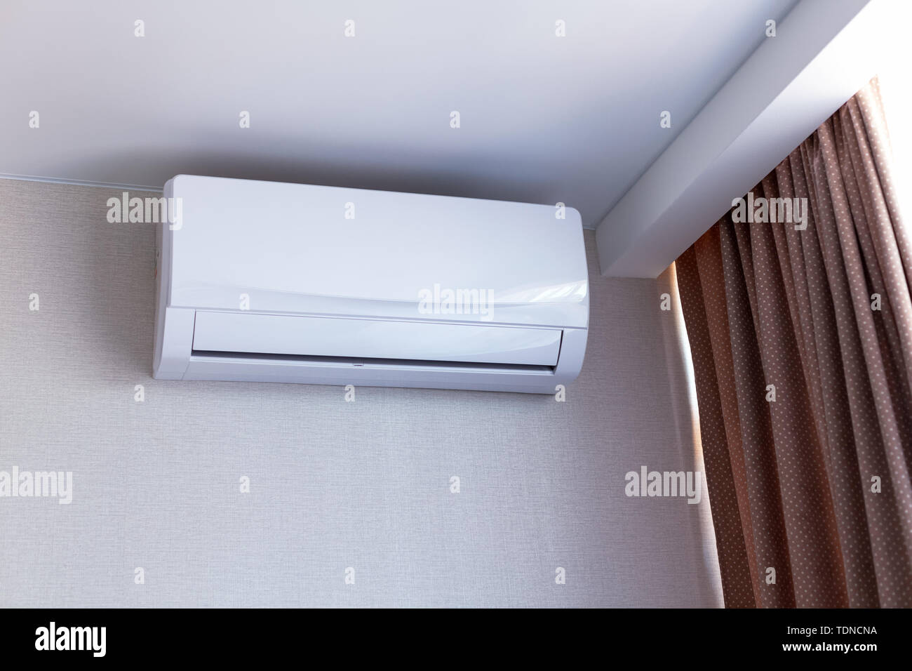 Kleine Klimaanlage an der Wand im Zimmer in der Wohnung, ausgeschaltet.  Interieur in ruhigen Beigetönen Stockfotografie - Alamy