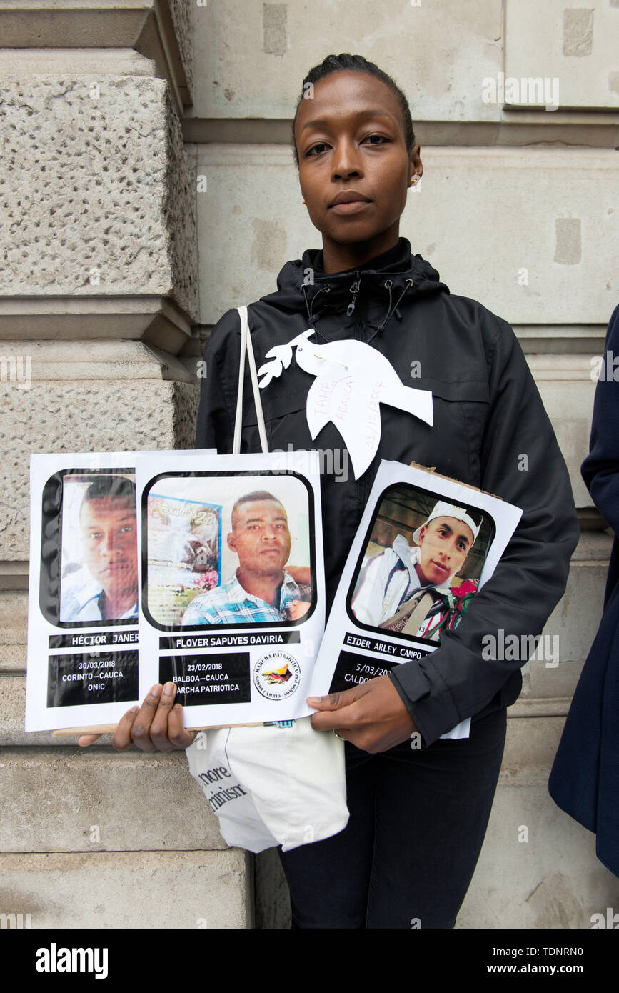 Demonstrator hält Plakate mit Fotos von Verantwortlichen des sozialen in Kolumbien während des Protestes getötet. Die Demonstranten versammelten sich vor Gibson Halle gegen kolumbianische Präsident Ivan Duque Besuch in London zu protestieren. Sie sind an die kolumbianischen rechten Regierung und der mangelnde Schutz der kolumbianischen Gesellschaft, die systematisch in Kolumbien in den letzten Jahren getötet wurden. Sie fordern Schutz für die Gesellschaft und die Umsetzung der Friedensabkommen mit den demobilisierten FARC. Demonstranten platziert eine 50 m lange Banner auf dem Bürgersteig außerhalb Gibson Hall mit dem Namen Stockfoto