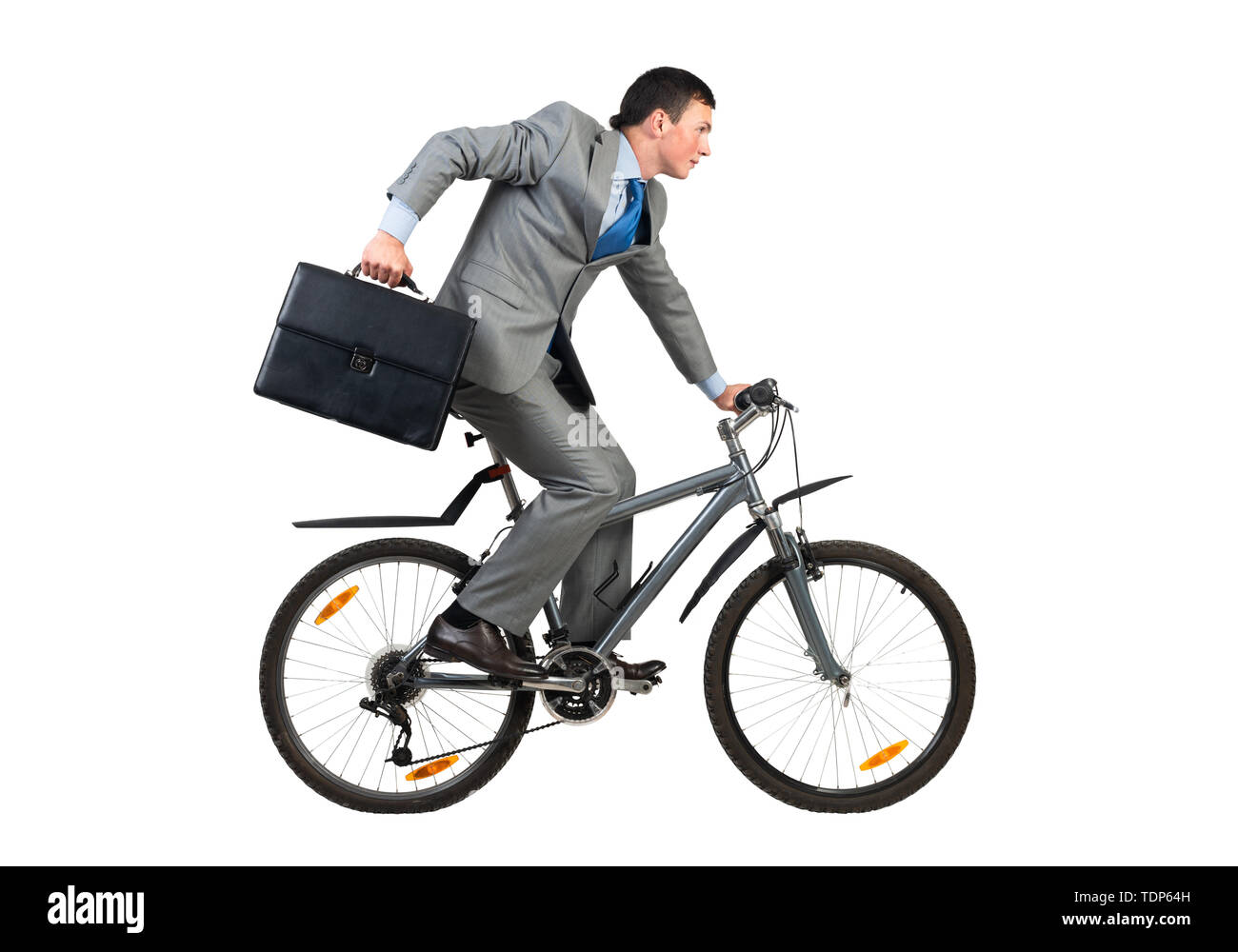 Geschäftsmann auf dem Fahrrad hast zu arbeiten. Junger Mann Angst, zu spät zu kommen. Mitarbeiter im grauen Anzug mit Koffer Reiten Fahrrad. Männliche Radfahrer Stockfoto