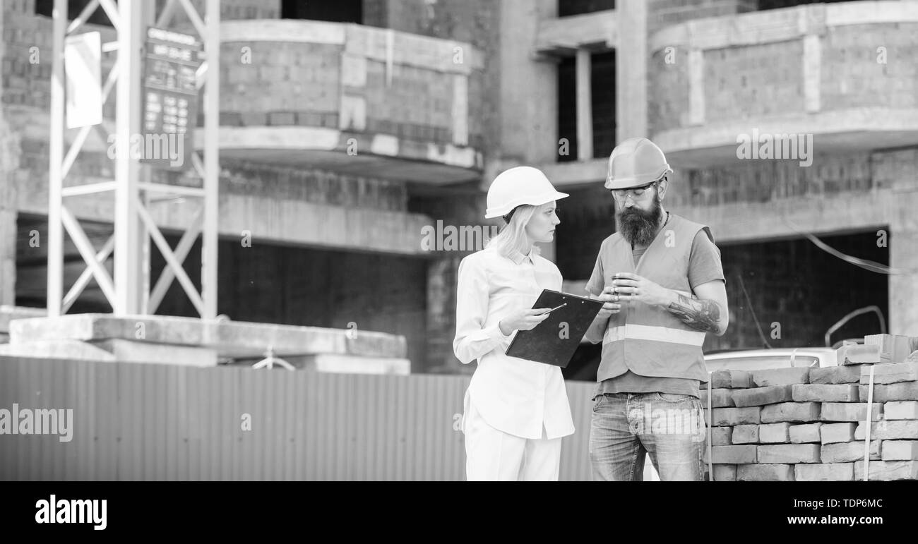 Bau team Kommunikationskonzept. Beziehungen zwischen den Kunden und Teilnehmer. Frau Ingenieur und Bauherr auf der Baustelle zu kommunizieren. Besprechung planen. Stockfoto