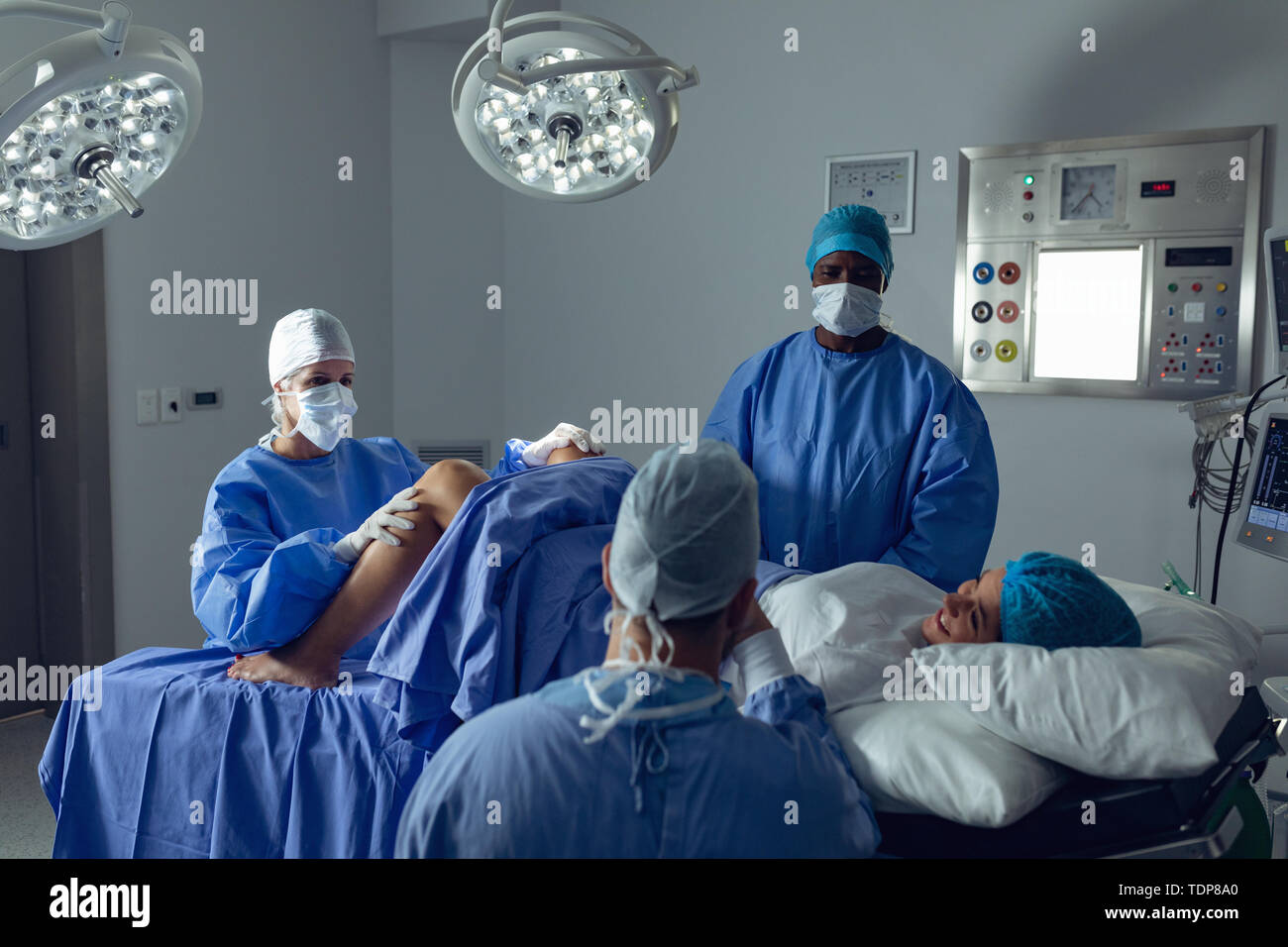 Chirurgen Prüfung schwangere Frau während der Lieferung während man ihre Hand im Operationssaal Stockfoto