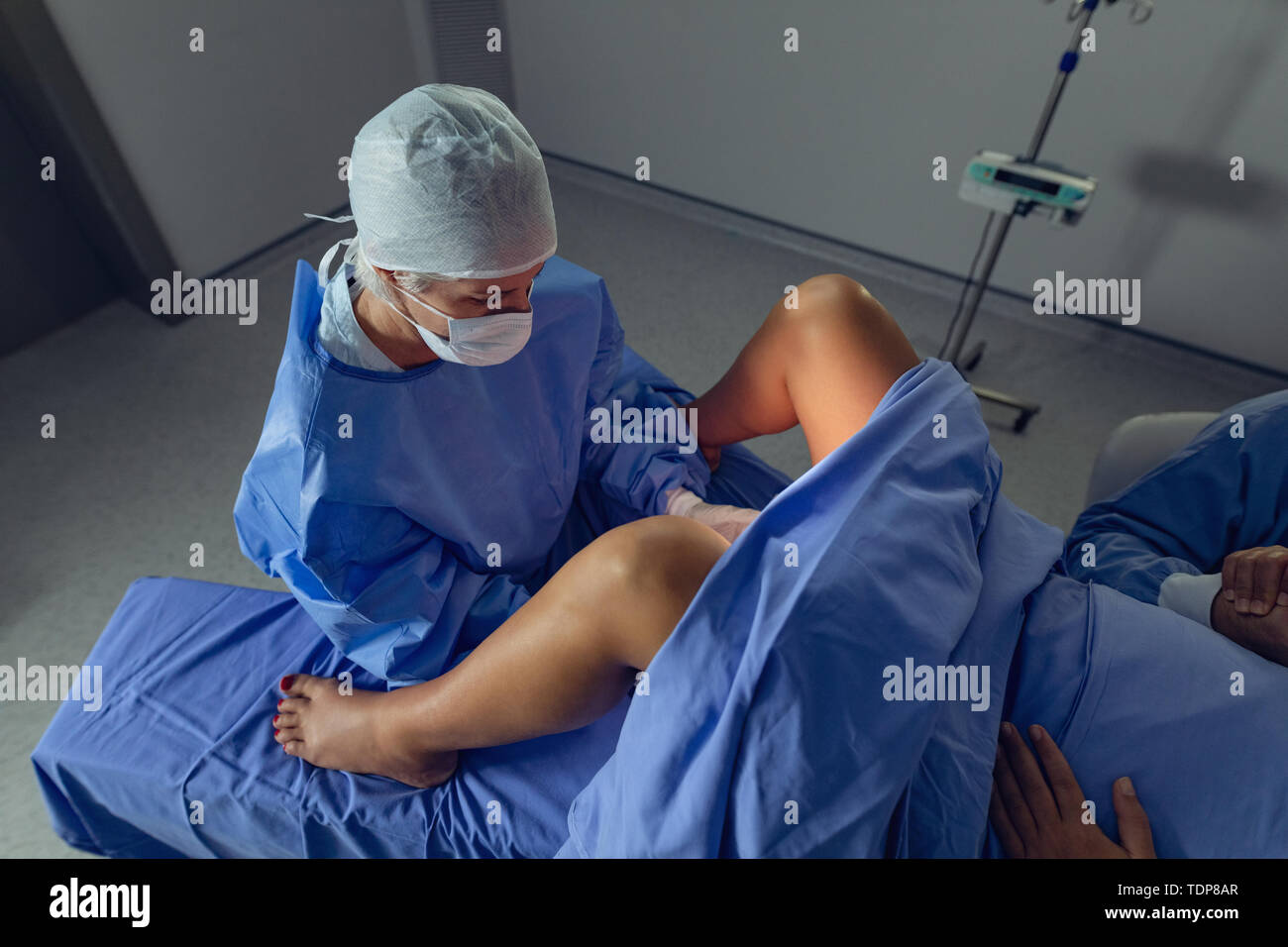 Chirurg Prüfung schwangere Frau während der Lieferung im Operationssaal Stockfoto