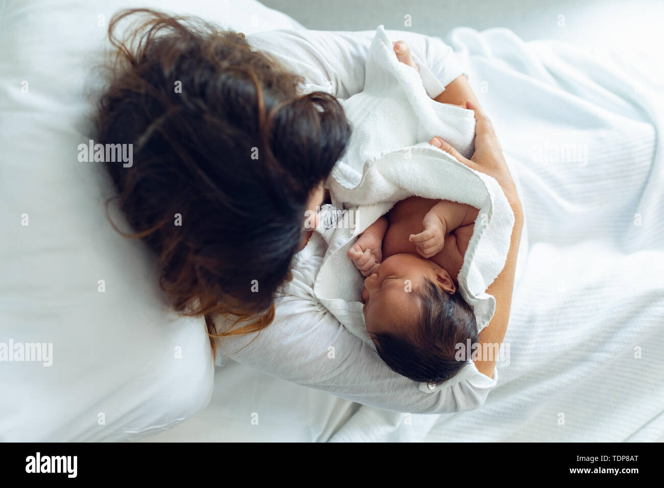 Die Mutter, die ihr neugeborenes Baby Kind nach der Arbeit in der Gemeinde Stockfoto