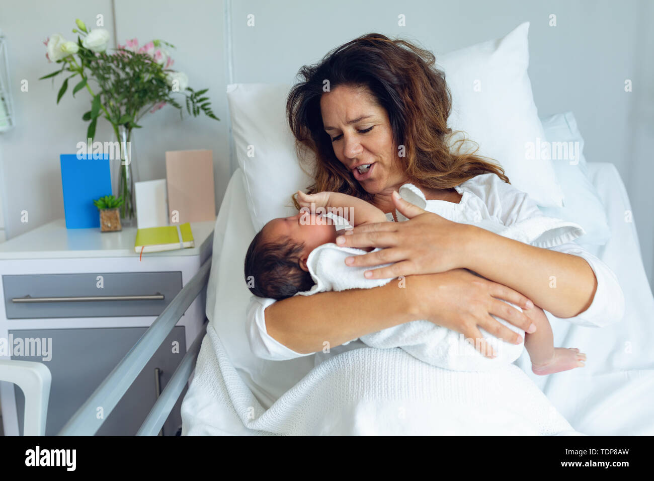 Die Mutter, die ihr neugeborenes Baby Kind nach der Arbeit in der Gemeinde Stockfoto Die Mutter, die ihr neugeborenes Baby Kind nach der Arbeit in der Gemeinde Stockfoto