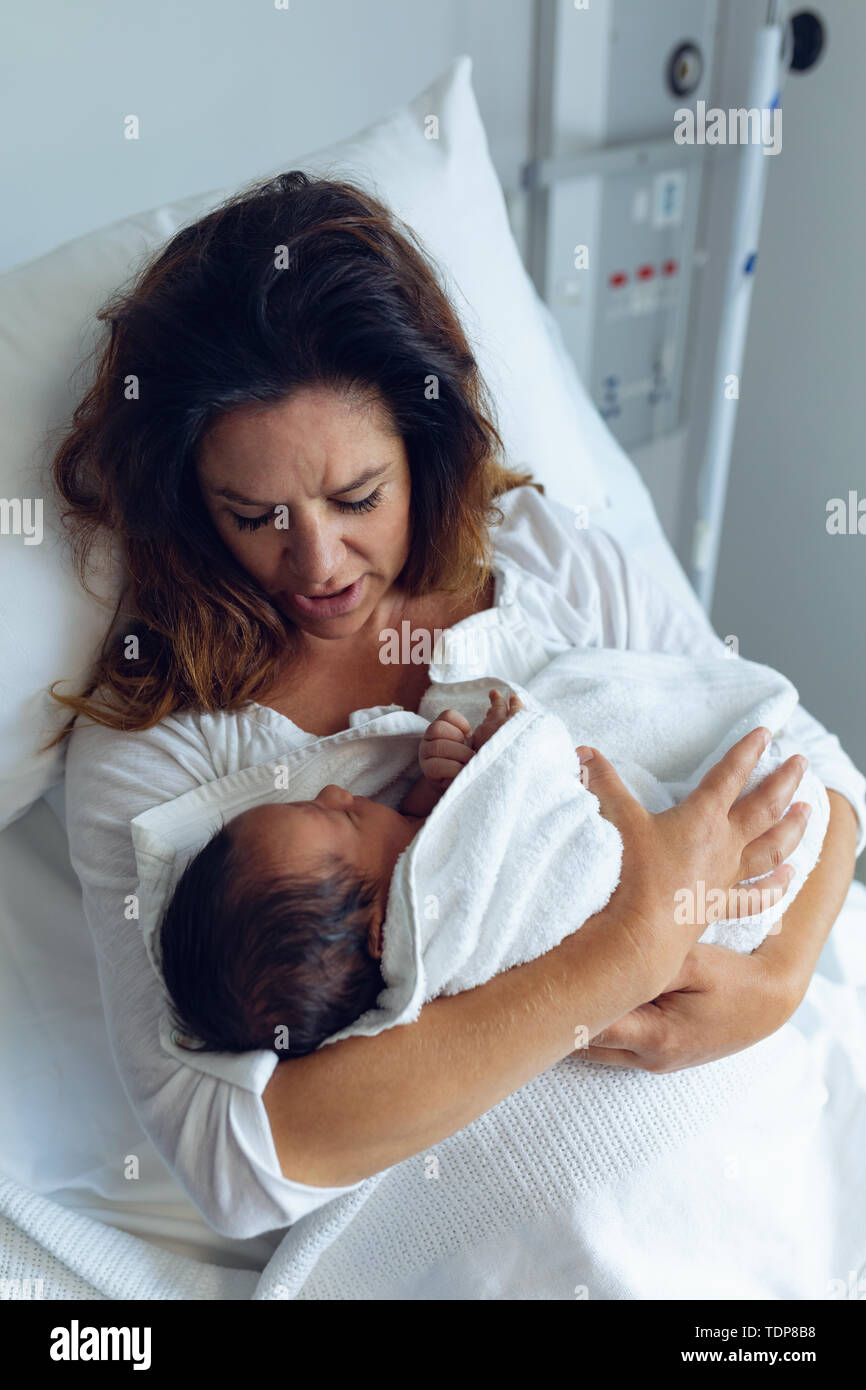 Die Mutter, die ihr neugeborenes Baby Kind nach der Arbeit in der Gemeinde Stockfoto