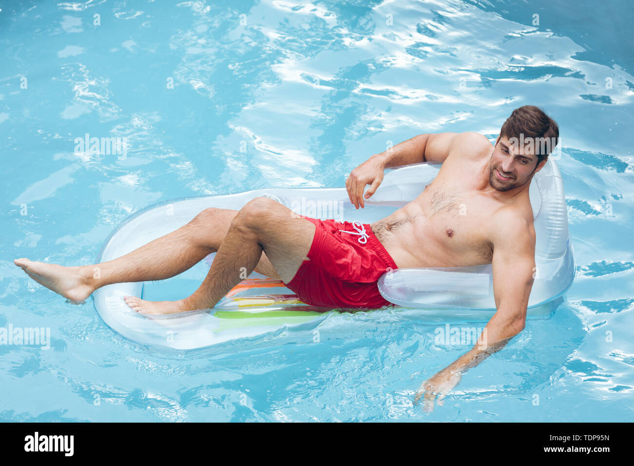 Mann entspannt auf einer aufblasbaren tune in Pool Stockfoto