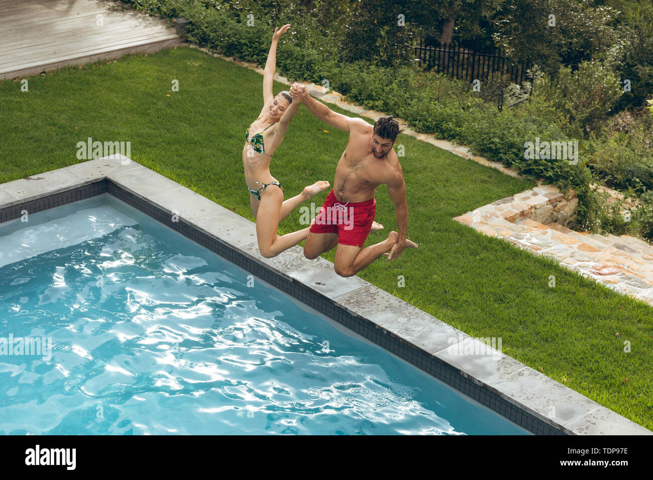 Paar zusammen einen Sprung in den Swimmingpool Stockfoto